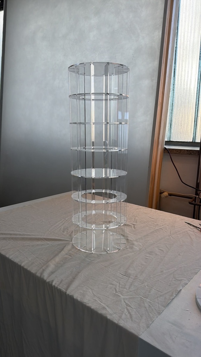 Transparente Säule aus Acryl mit senkrechten Stegen und mehreren waagerechten Ringen