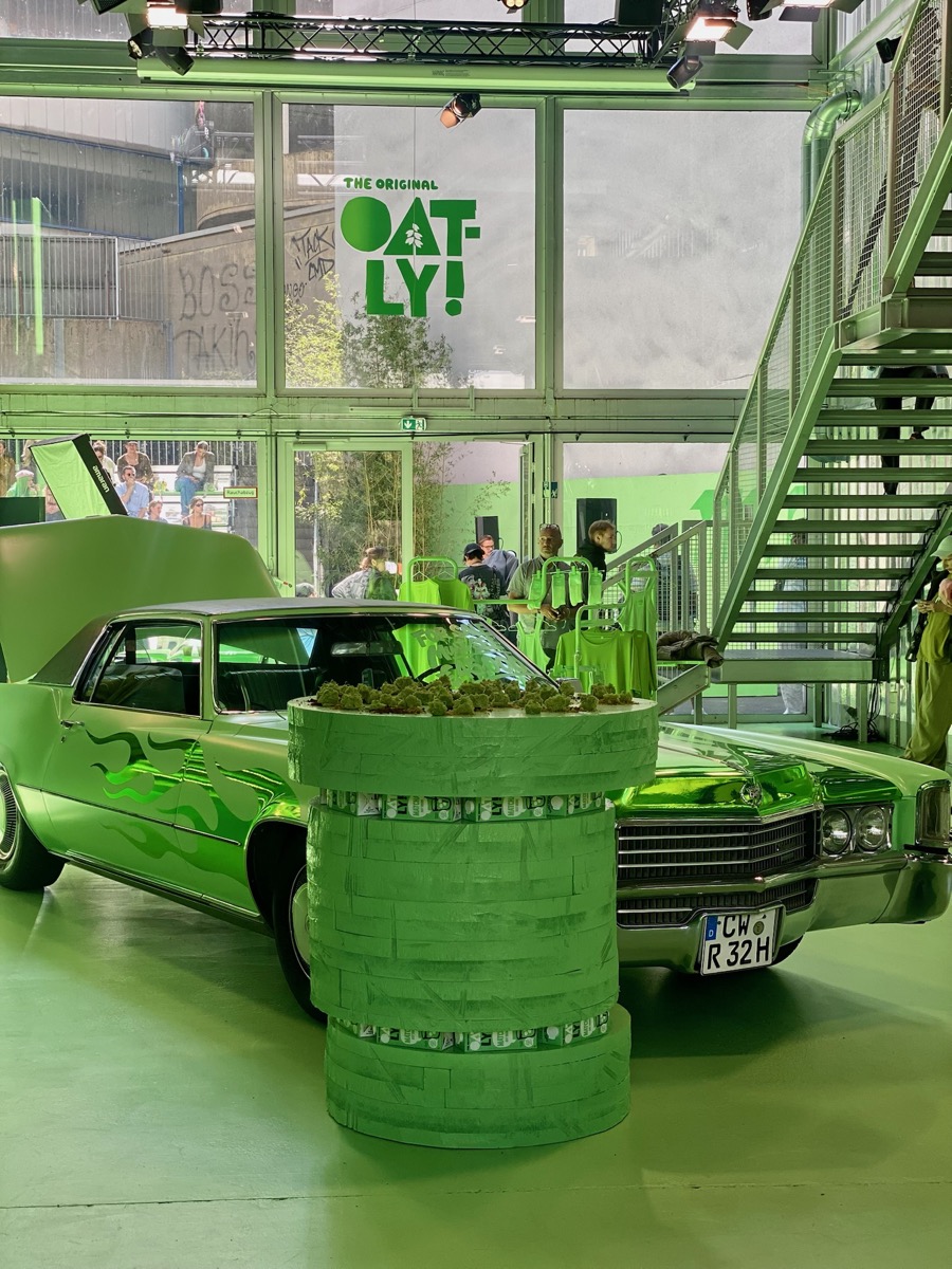 Grüner Säulentisch mit Pflanzen vor einem grün foliertem Oldtimer beim CeeCee-x-Oatly-Event