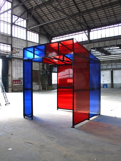 Pavillon aus rotem und blauem Glas in einer Halle