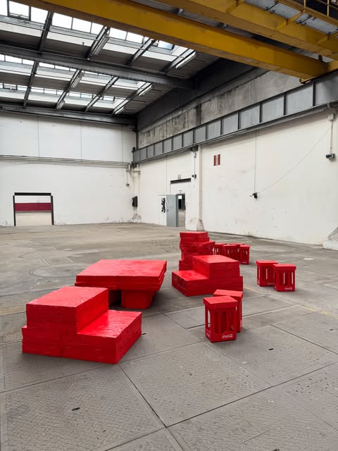 Rote Sitzlandschaft aus Getränkekisten in einer Halle